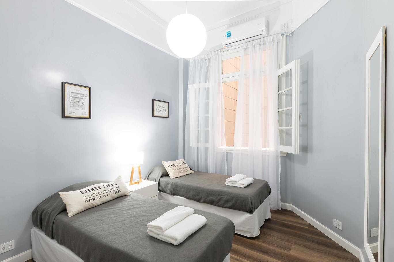 chambre avec deux lits simples, mur gris à l'hôtel du port